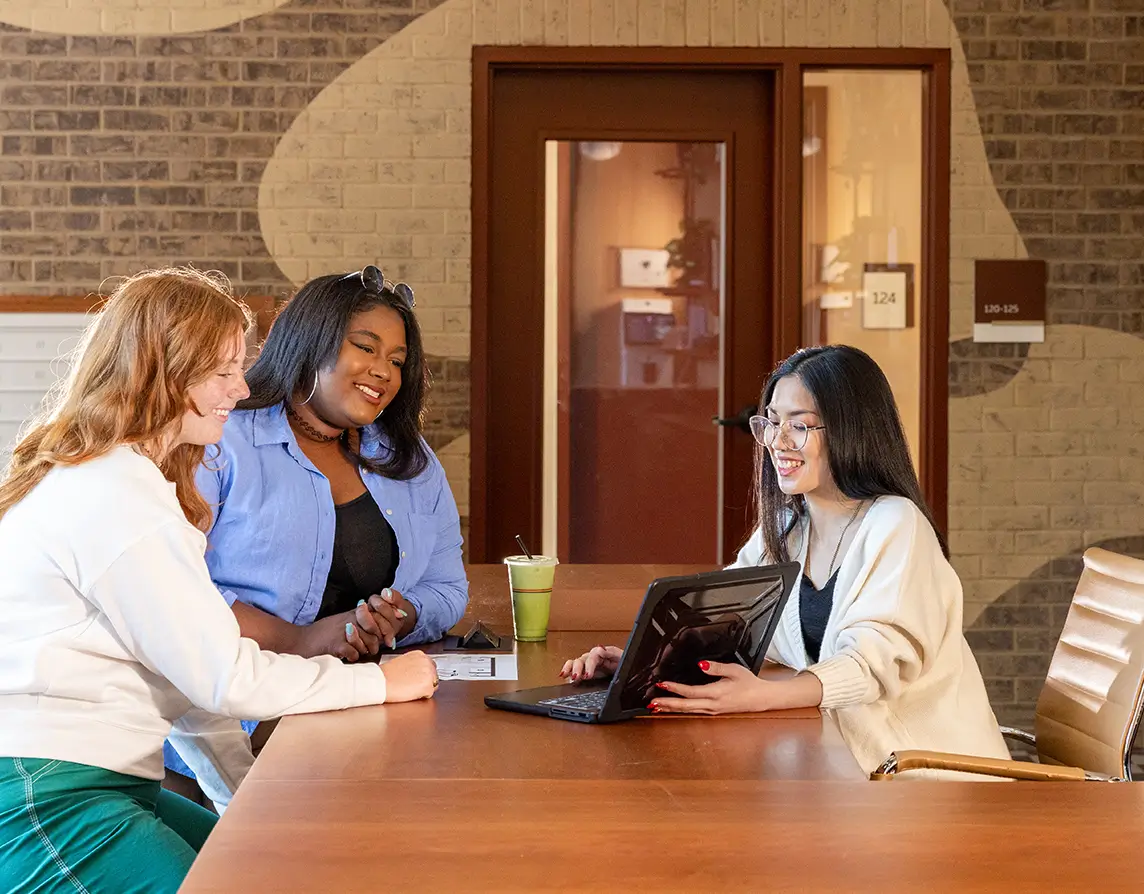 a group of people using a laptop